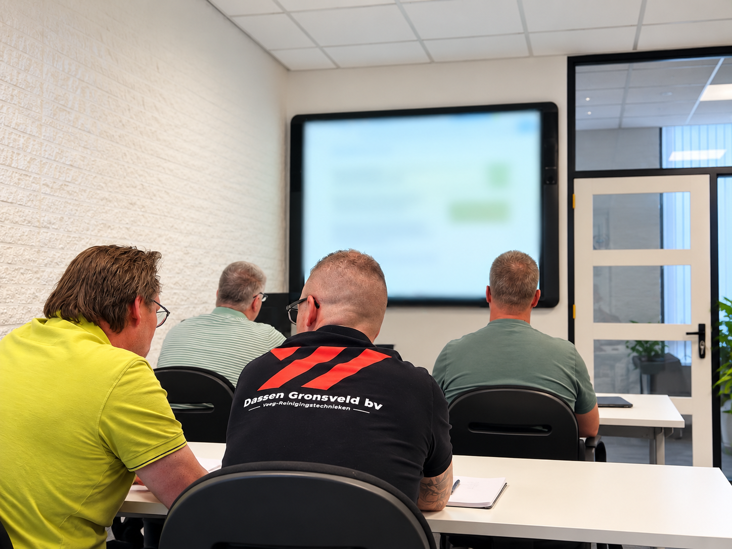 Deelnemers tijdens een klassikale VCA-training; Dassen Gronsveld zichtbaar op bedrijfskleding